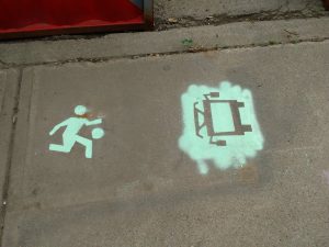 A chalk drawing of a child playing ball and a transit vehicle on a sidewalk