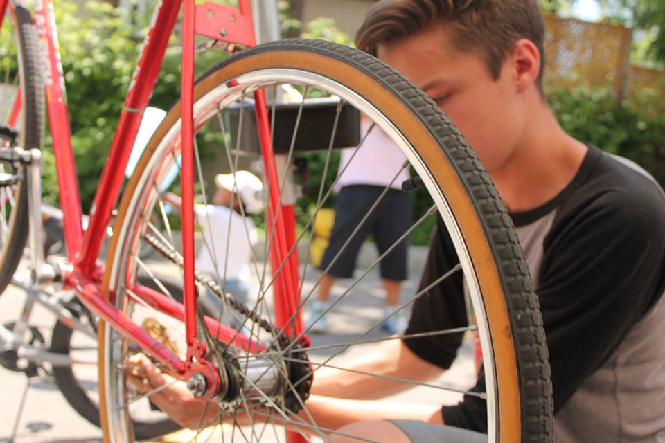 A person fixing a red bicycle